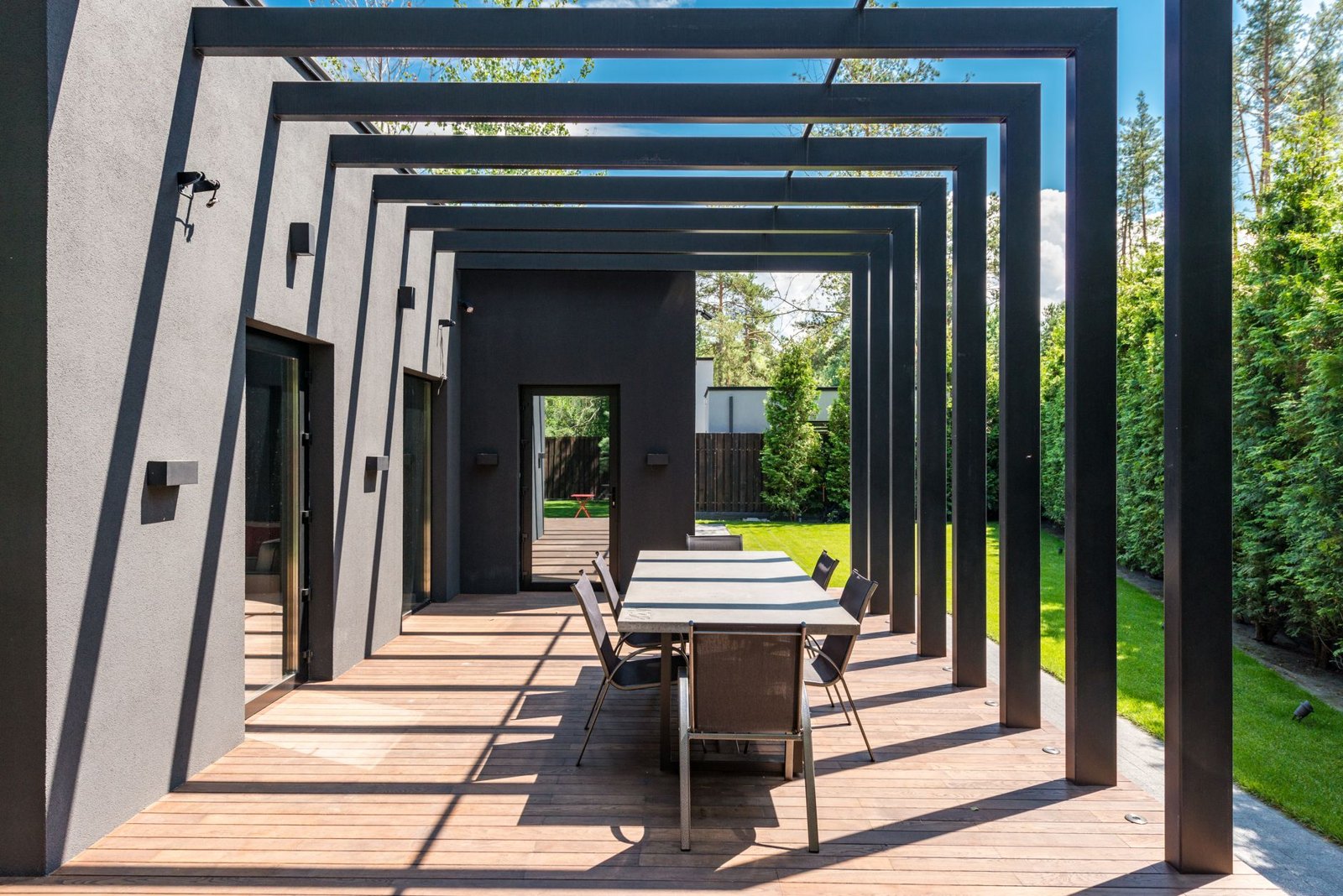 Timber pergola with integrated lighting over an outdoor lounge, UAE villa